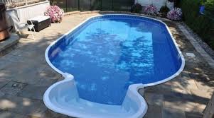 A semi inground swimming pool with wooden deck. Creative Homescapes Semi Inground Pool