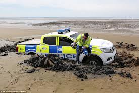 police car sinks into sand and gets