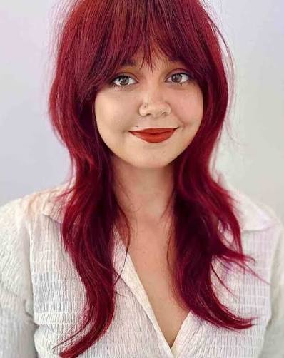 If you are looking to shape your round face with your long hair, you must try a long shag with wispy bangs. Explore more photos like this by clicking the link in