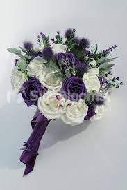 Im Kinda Liking The Darker Purple This Is An Arrangement Of Ivory Roses Thistles Sea Holly And Heath Purple Wedding Flowers Wedding Flowers Wedding Bouquets