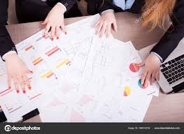 Two Women With A Lot Of Charts On The Table Stock Photo