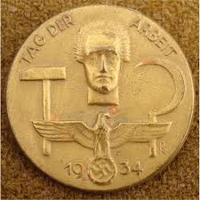 It is constructed out of a die stamped tombak base that has been gold gilded. 1934 Tag Der Arbeit Medal Eagle Swastika W Worker