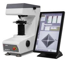 PC 화면에 비커스 압흔이 크게 확대되어 있고, 소프트웨어가 자동으로 꼭지점을 찾아 대각선 길이를 측정해 경도 값을 띄워주는 모습