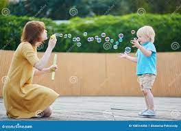 Mother Blowing Bubbles and Playing with Her Little Son Stock Photo - Image  of people, celebration: 100514356