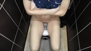 Skinny girl pissing in the toilet.