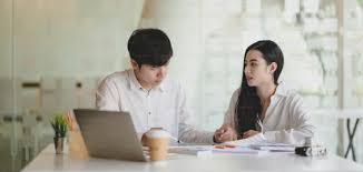 Foto Dua desainer grafis profesional muda mengerjakan proyek mereka bersama dengan komputer laptop di ruang kantor modern – Gambar Kantor di Unsplash