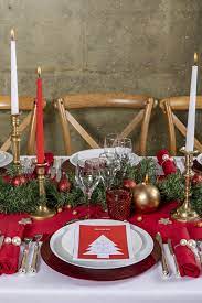 le vert des branches du sapin le rouge sur le linge de table et les verres et quelque decoration table de noel table de noel traditionnelle table de fete noel