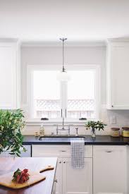 Our kitchen design process has been like a presidential campaign: Light Over Kitchen Sinkl Transitional Kitchen Amanda Teal Design