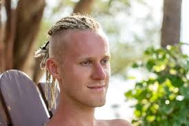 Ritratto di un giovane ragazzo con i dreadlocks in testa in natura. Felice  bell'uomo con i dreadlocks sulla spiaggia tropicale, primo piano
