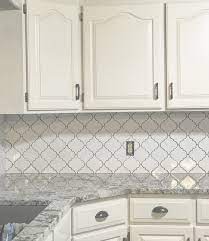 A white tile backsplash can blend further with your white cabinets, allowing appliances and smaller color splashes to take center stage. White Kitchen Cabinets White Arabesque Tile Backsplash Gray Nuevo Granite Coun White Arabesque Tile Arabesque Tile Backsplash Kitchen Cabinets Grey And White