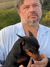 O Pinscher Correndo Atrás Do Menino