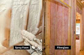 Side-by-side comparison showing fiberglass batts next to hardened spray foam insulation.