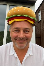 BACK IN MONDAY. The Twat in the Hat came swaggering back, From holidays  boozing and turning quite slack. He'd burned his big belly, got sand in his  crack, But Patterson's Butchers still