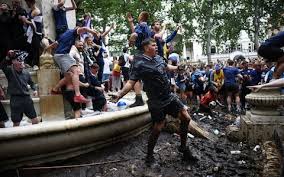 A scotland fan with bagpipes tries to kick a ball. Football Fans Arrested As Tartan Army Takes Over London