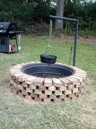 This Is Our Fire Pit Made From Tractor Rim And Reclaimed Bricks Husband Constructed Swivel Post To Hang Cook Cheap Fire Pit Outside Fire Pits Fire Pit Grill