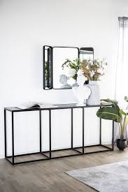 The table's sturdy rectangular base, made from dramatic black dune marble, supports a round marble top with a slight lip around the edge, ideal for keeping a drink or favorite book nearby. Eleonora Sidetable Marmer 180x40 Max Wonen