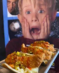 MACaulay Cluckin Tacos” Seasoned and fried chicken breast sliced into 3  strips laid over a bed of our creamy white cheddar Mac & cheese, topped  with a drizzle of Buffalo sauce and