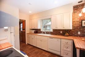 The whitewashed brick backsplash is given country style kitchen looking with white cabinets and dark counters. Kitchen Refresh Brick Backsplash Painted White Cabinets Castle Building Remodeling Inc Twin Cities Design Build Firm