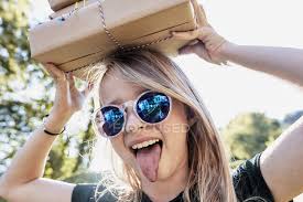 Maybe you would like to learn more about one of these? Girl Sticking Tongue Out With Box On Head Close Up Sunglasses Stock Photo 199889626
