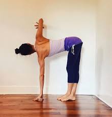 Folded Standing Twist With Wall Assist Yoga Yoga Asanas Wall Yoga Yoga Routine
