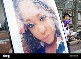Inez Ross walks past a photo of her daughter Roseann McCulley, before the  start of a End Domestic Violence rally in Clayton, Missouri