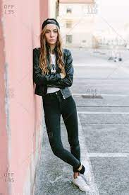 Up against can mean to be firmly pressed against something. Fashionable Young Woman Wearing Baseball Cap Leaning Against Wall Stock Photo Offset