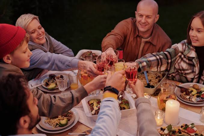 Cheerful family toasting during evening dinner · Free Stock Photo