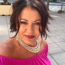 Fresno Police officer Katrina Lloyd flashes a peace sign to protesters as  they pass police headquarters, Sunday afternoon. A message from Police  Chief Hall