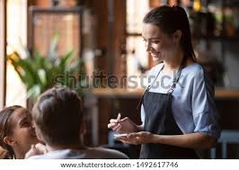 Mature waitress serves a visitor. Shutterstock Puzzlepix