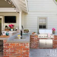 A long bar has white chairs on one side for an eating space. Outdoor Kitchen Ideas Better Homes Gardens