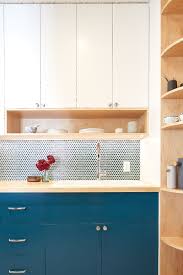 Remember, open shelving isn't limited to farmhouse style. This Small Kitchen Features A Pegboard Wall And Open Shelving For Extra Storage