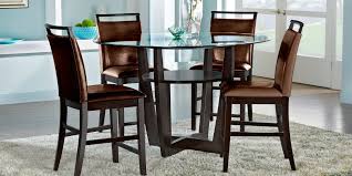 Circular designs accent the round drum table base. Glass Top Dining Room Table Sets