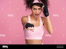 curly young woman in sportswear with bondage on hands screaming while  exercising isolated on pink Stock Photo - Alamy
