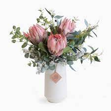 Pink Protea Eucalyptus And Tetra Nuts In Vanilla Vase Flower Vase Arrangements Pink Flower Arrangements Artificial Flower Arrangements