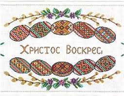 A little white easter bunny is jumping over some brightly colored easter eggs, while below it wishes everyone a happy easter surrounded by some spring tulips. Easter Basket Cover Chart And Poster Set Ukrainian Gift Shop Easter Embroidery Easter Baskets Easter Cross
