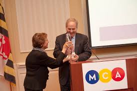 MCA Trustee Sue Hess presents E. Scott Johnson with the 'S…