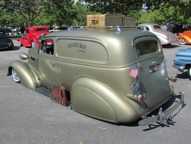 Sedan Delivery with custom roof rack, fulton style visor, rear fender skirts and sitting slammed on the ground in the weeds. Truck also has one of those super awesome luggage racks on