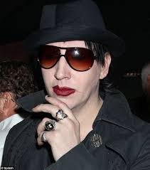 Marilyn Manson tries to thwart paparazzi at LAX by scrawling f*** you  across his face