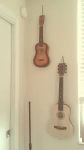Listing out the best guitar stands and guitar wall hangers offers many choices. Guitars Hanging On Wall Just Used Birthday Ribbon And Hammered A Nail Music Room Decor Hang Guitar On Wall Guitar Wall