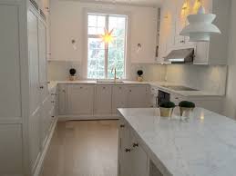 The black pendants lights over the kitchen islands are from rejuvenation. Light Grey Kitchen With Carrara Marble Countertops And Kitchen Island Kitchen Inspirations Marble Kitchen Worktops Kitchen