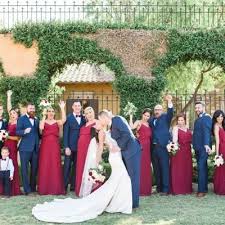 Bridal Party Celebrates In Red Bridesmaid Dresses And Navy Blue Suits As The Bride And Groom Share A Navy Bridal Parties Red Bridesmaids Red Bridesmaid Dresses