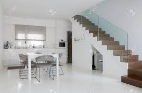 Usually epoxy floor installation is done in places like hospitals that require industrial floors, because they are the most antiseptics and less prone to the spread of bacteria and all the variety of things in health care centers. White Kitchen And Dining Room With White Epoxy Floor And Wooden Stock Photo Picture And Royalty Free Image Image 50382911