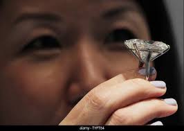 A woman holds a cushion-cut K color diamond of 80.73 carats that is