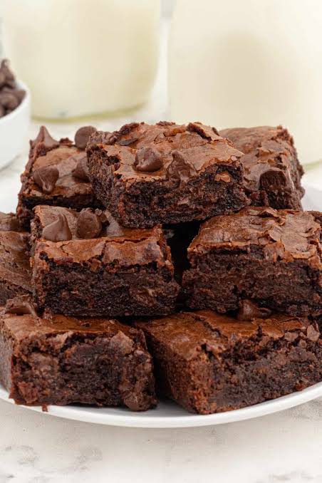 Double Chocolate Fudgy Brownies stacked on a plate with a crackly top