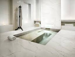 This tiny bathroom is made to feel luxurious and much larger by the inclusion of mirror all around the room. Large Marble Effect Bathroom Tiles Carrara Marble Effect