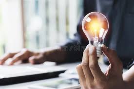 Business Woman Holding Light Bulb On The Desk In Office And Using Computer In Sponsored Bulb Desk Offic Light Bulb Business Women Financial Accounting