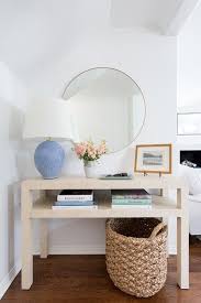 Aerin Toulon Table Lamp On A Tan Grasscloth Console Table Styled With Florals Books And A Picture Frame Blue Console Table Console Table Styling Interior
