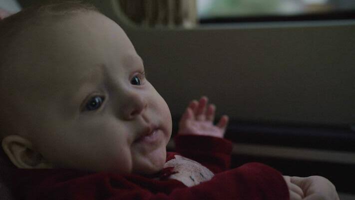 Cute baby girl of six months traveling with mum by car