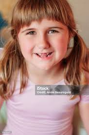 Una Niña Que Está Medio Con Un Diente Perdido Y Dos Coletas Foto de stock y  más banco de imágenes de 6-7 años