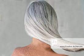 Rückansicht der nackten, reifen Frau mit langen grauen Haaren